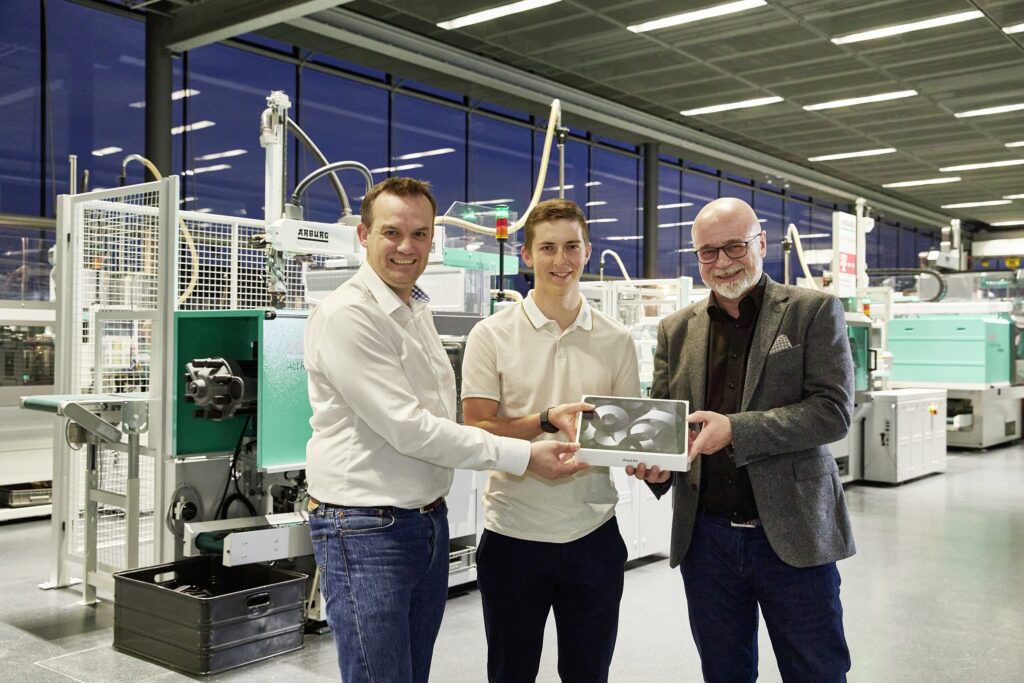 Lucky winner: Stephan Reich, Director IT Digital Solutions (left) and Dr Christoph Schumacher, Director Global Marketing (right), hand over the iPad to Maximilian Vetter (centre).
