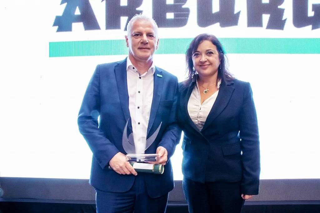 Leandro Goulart, Head of Marketing and Sales Arburg Brazil, accepts the PPR for "TOP Equipment in Electric Drives" for Arburg from Jane Campos, Radici Plastics Ltda.